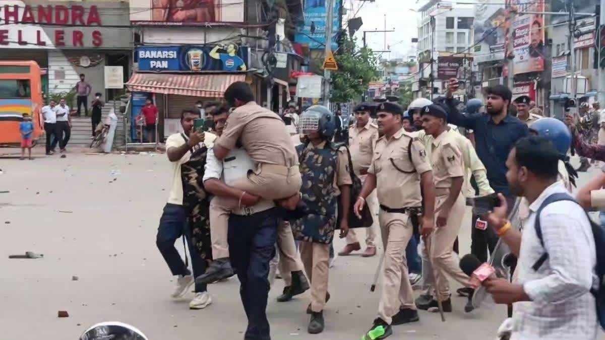 An injured police official is being taken away from the protest site. (ETV Bharat)