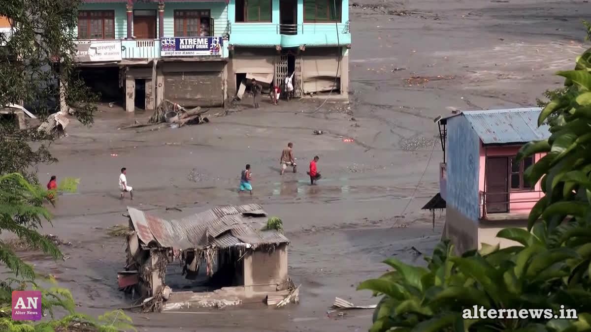 People walk through knee-deep mud in a residential area following a flash flood caused by an outburst in the Bhotekoshi River, in Nuwakot (ANI Videograb)