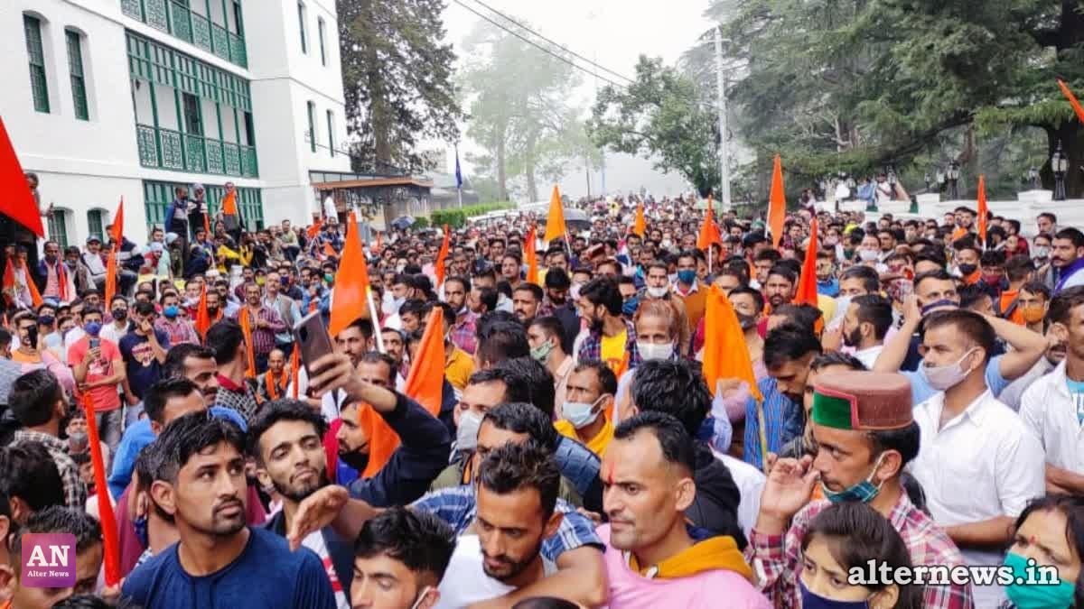 People hold flags during a protest demanding the upper caste commission in Shimla.